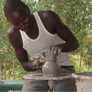 La sfida del microcredito e dell'artigianato: un ragazzo impara a lavorare l'argilla